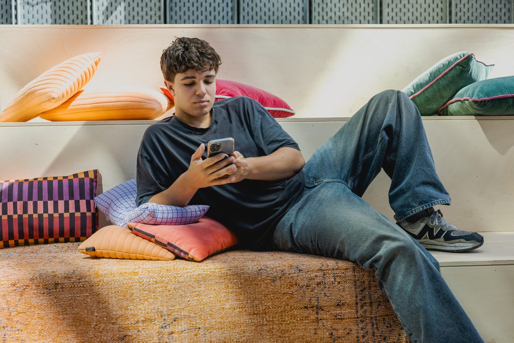 Student checkt de vibe van het GLU vanaf de bank.