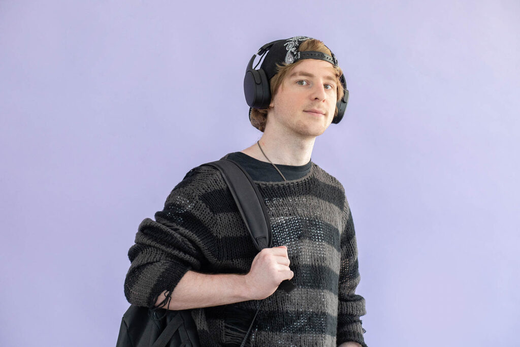 Student staat voor een paarse muur