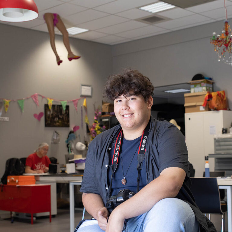 Student kijkt lachend in de camera