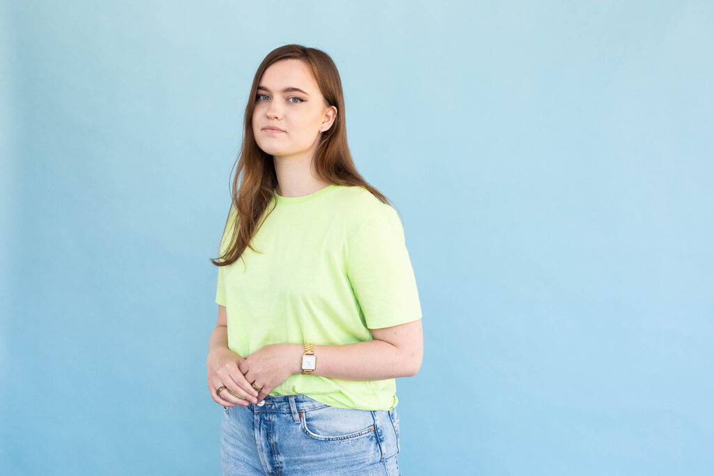 Student Claire poseert voor blauwe muur