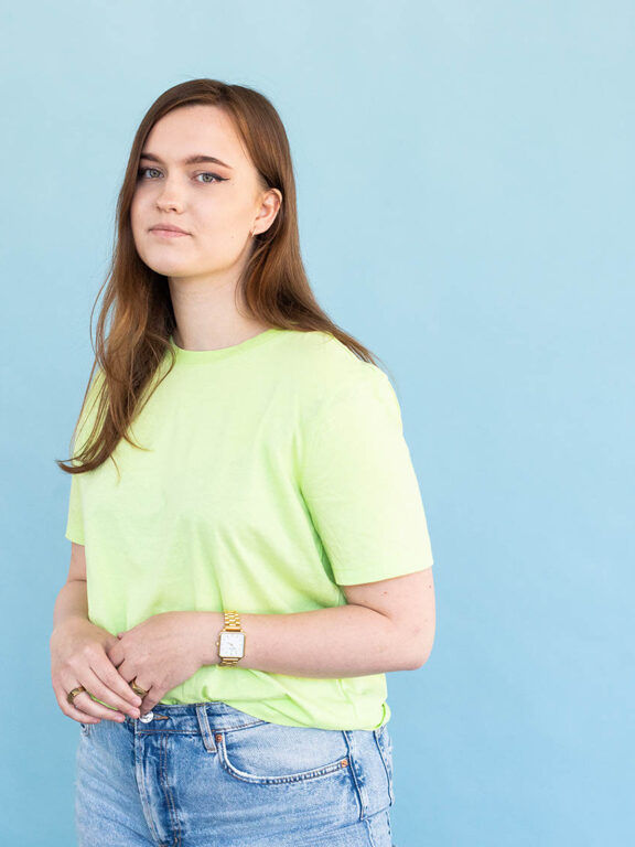 Student Claire poseert voor blauwe muur