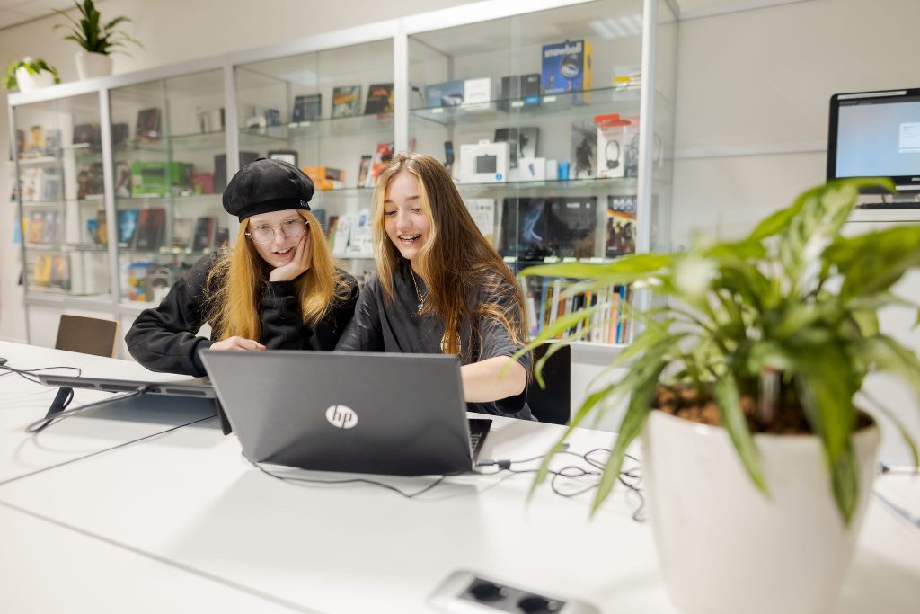 Studenten bekijken het werk op een MacBook