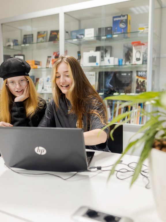 Studenten bekijken het werk op een MacBook
