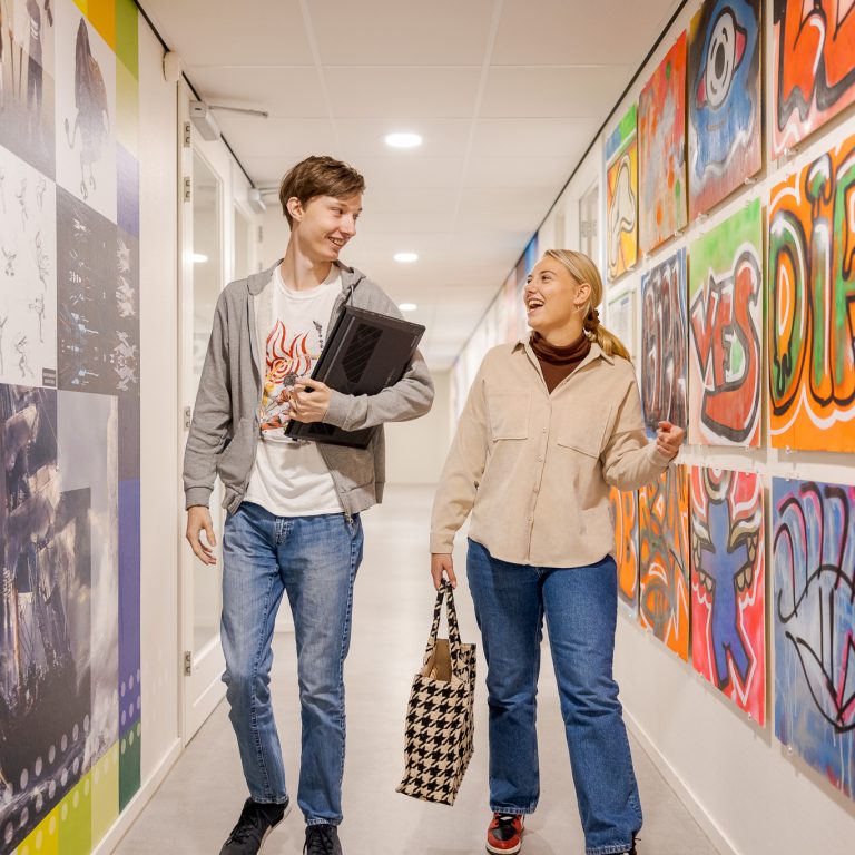 Studenten wandelen door de gangen van de Koningin Wilhelminalaan.