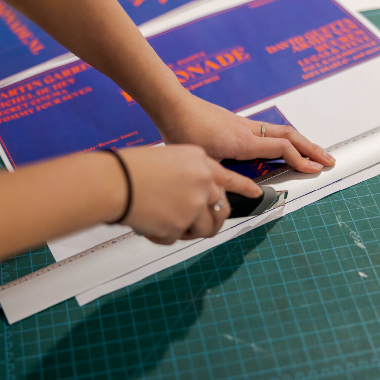 Student is de poster aan het bijsnijden