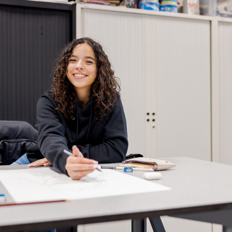 Student schetst op papier.