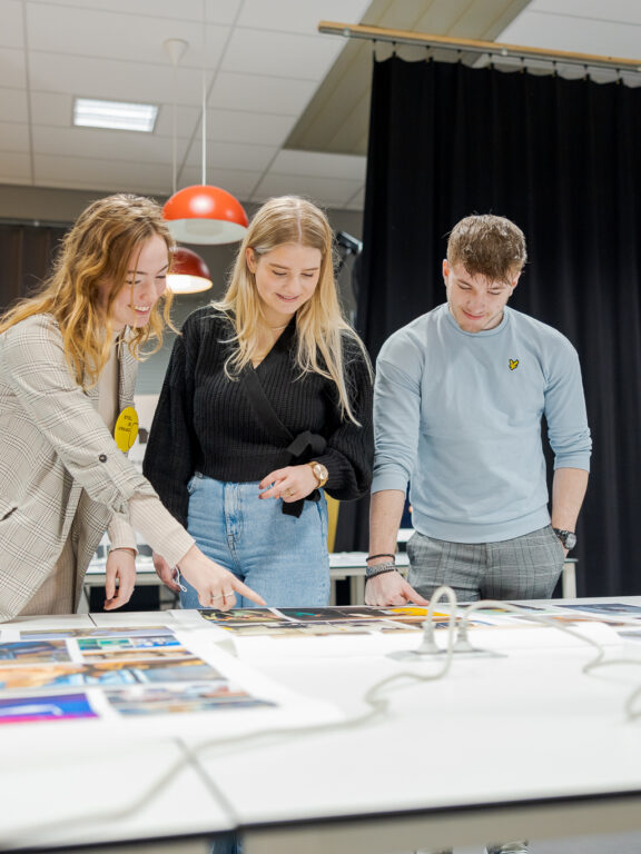 Studenten bekijken werk van hun medestudenten.
