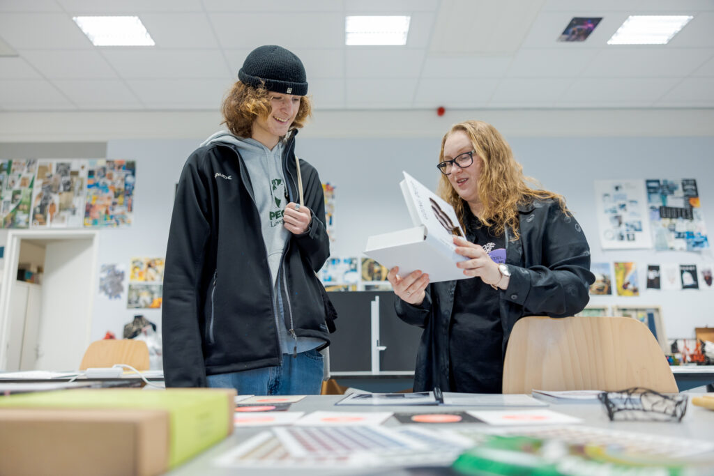 Studenten bekijken werk van een Grafisch Vormgeving student