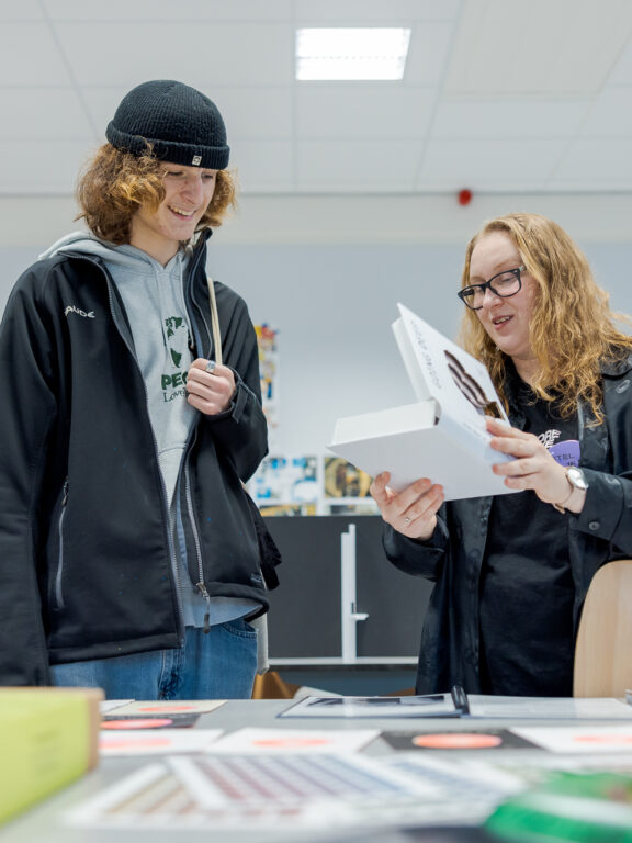 Studenten bekijken werk van een Grafisch Vormgeving student