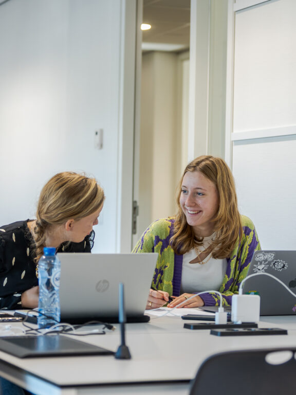 Twee studenten Crossmedia aan het werk op de computer.