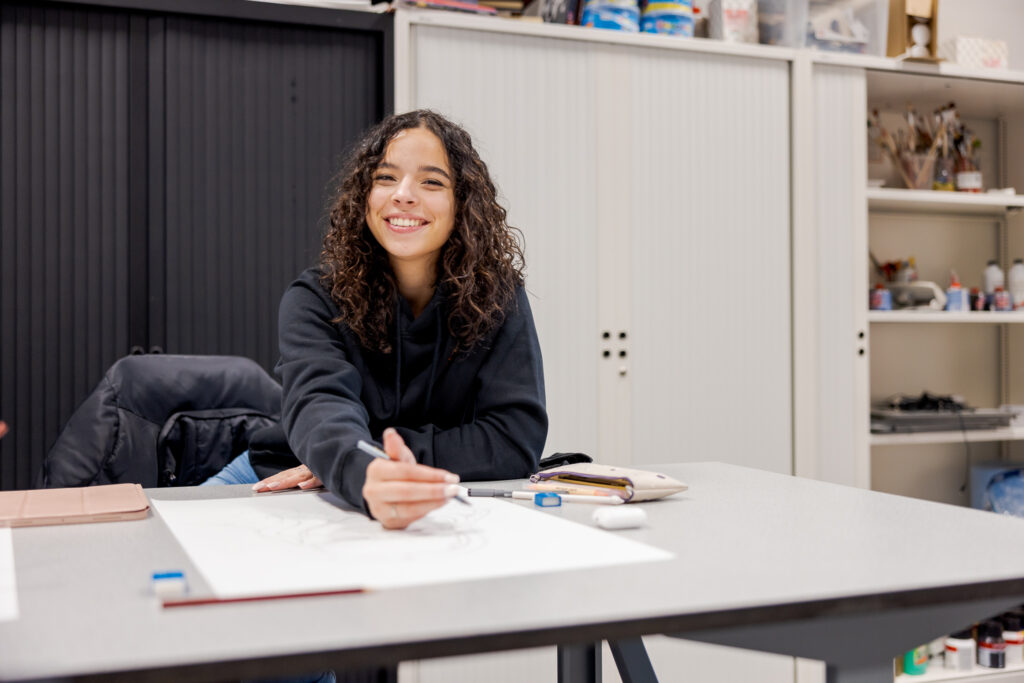 Grafisch Vormgeving student bezig met tekenen tijdens het keuzedeel illustreren.