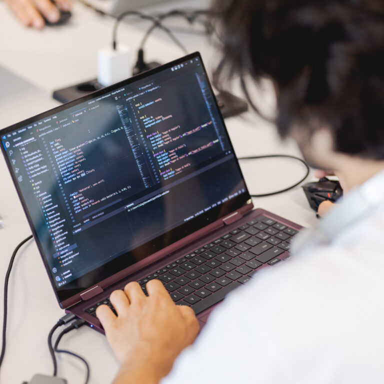 Student programmeert op laptop.