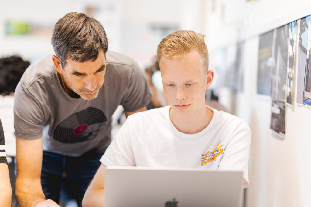 Docent legt iets aan student uit.