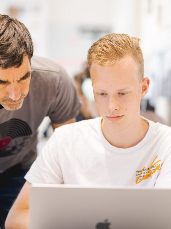 Docent legt iets aan student uit.