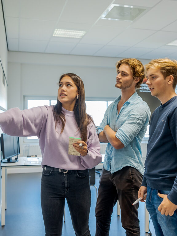 Studenten overleggen rondom een camban bord
