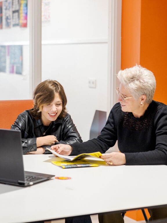 Docent is feedback aan het geven op de opdracht die een student heeft gemaakt.