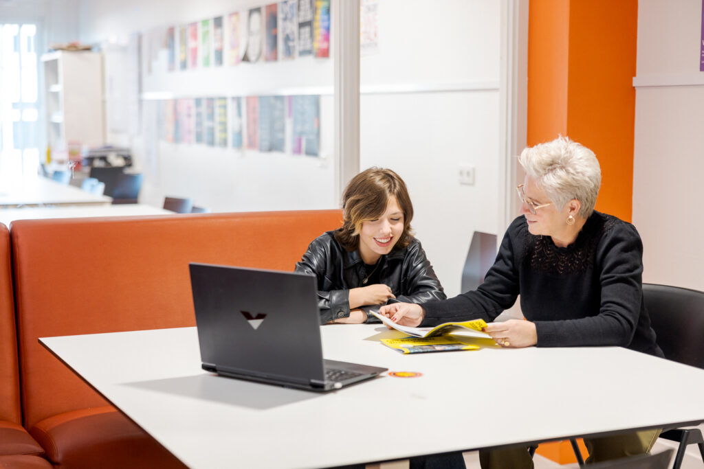 Docent is feedback aan het geven op de opdracht die een student heeft gemaakt.