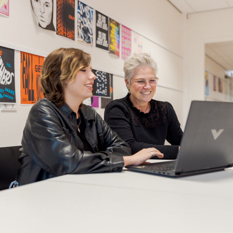 Docent is feedback aan het geven op de opdracht die een student heeft gemaakt.