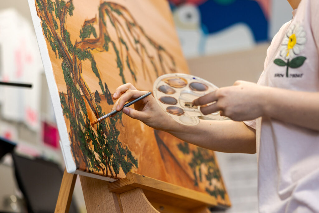 Student Creative Media Design is aan het schilderen in de creatieve werkplaats.