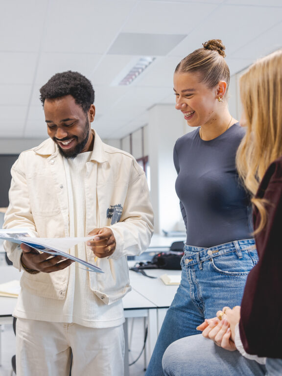 Studenten van de opleiding Creative Marketing en Communication bekijken hun nieuwe opdracht.