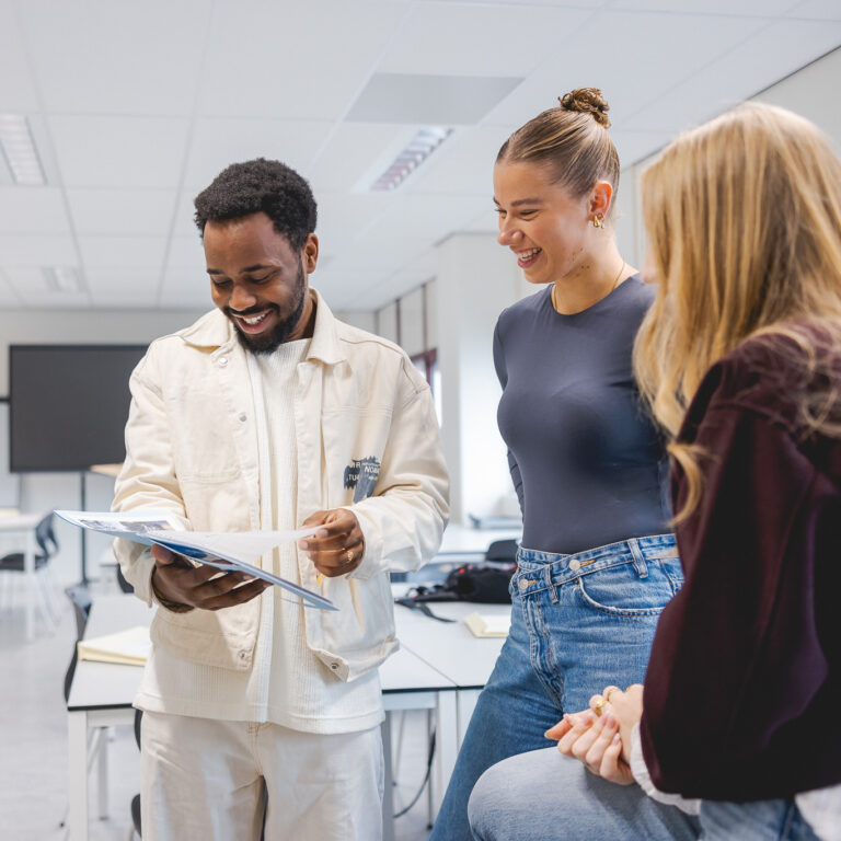 Studenten van de opleiding Creative Marketing en Communication bekijken hun nieuwe opdracht.