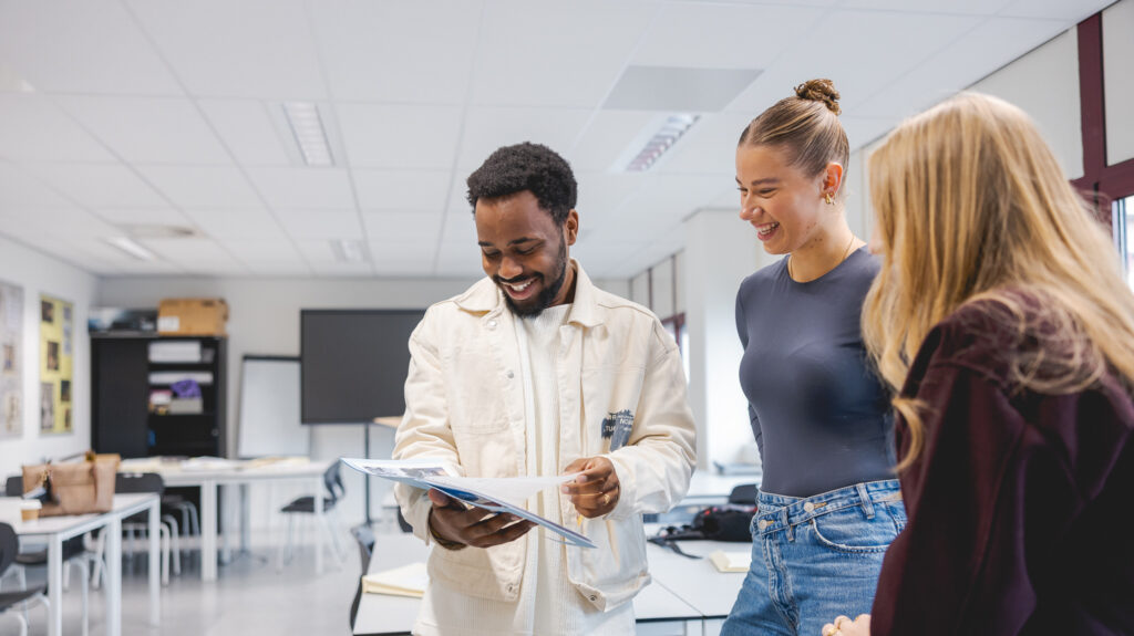 Studenten van de opleiding Creative Marketing en Communication bekijken hun nieuwe opdracht.