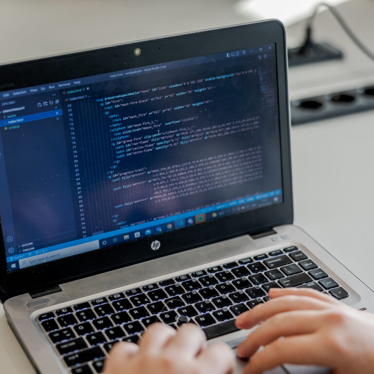 Student is aan het coderen achter zijn laptop