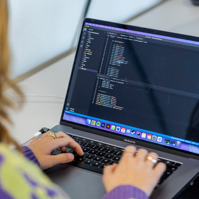 Een student aan het coderen op de laptop