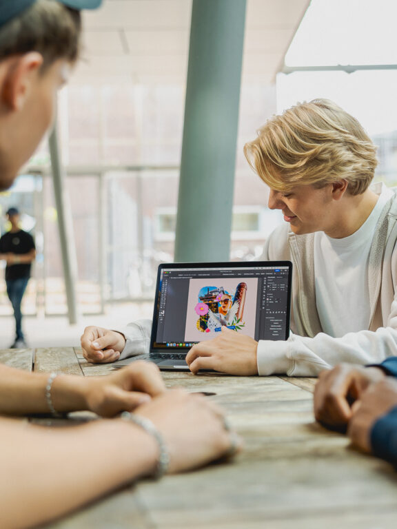 Studenten bekijken het werk van een mede student