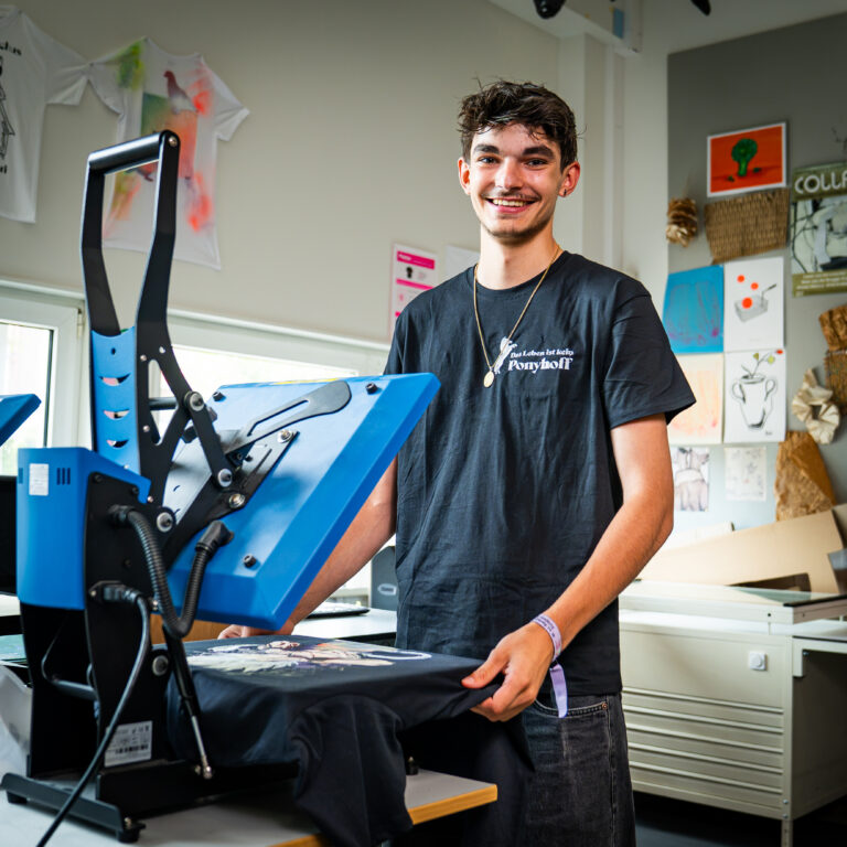 Student is bezig met het bedrukken van een t-shirt