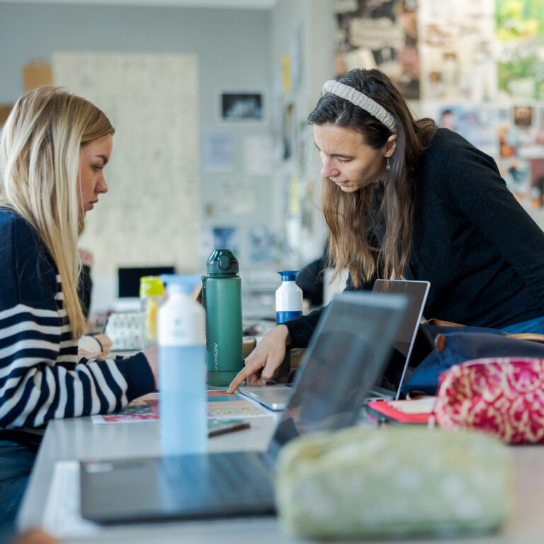 Docent geeft uitleg aan een student