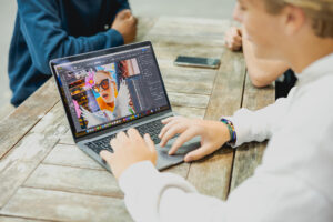 Student werkt op zijn MacBook aan een grafische opdracht.
