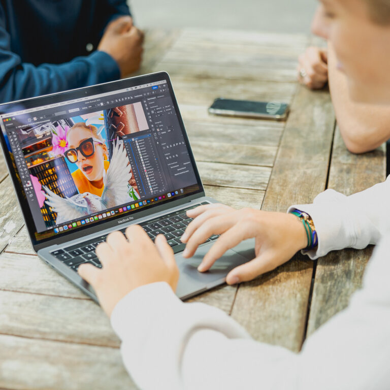 Student werkt op zijn MacBook aan een grafische opdracht.