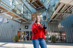 Student fotografeert in het atrium van de school