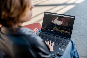 Student bewerkt een video op de rode bank.