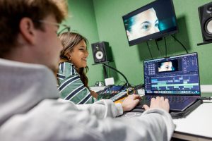 Student monteert een film in een studio.