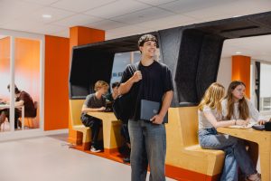 Student staat in de gang van de school.
