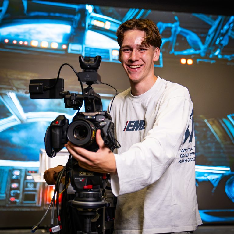 Student filmt met een camera op een statief.